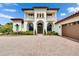 Mediterranean-style home with a red tile roof, arched entryways, a spacious driveway, and well-maintained landscaping at 16406 Chapman Crossing Dr, Lithia, FL 33547