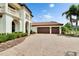 Elegant home with a three-car garage, brick-paved driveway, red tile roof and well-manicured landscaping at 16406 Chapman Crossing Dr, Lithia, FL 33547