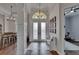 Bright foyer featuring tile flooring, a decorative chandelier, and views of the dining area and exercise room at 16406 Chapman Crossing Dr, Lithia, FL 33547