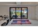 View of a bright game room that opens to an outdoor patio with seating and nature views at 16406 Chapman Crossing Dr, Lithia, FL 33547
