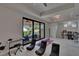 Well-lit game room with outside access, modern gaming chairs, and recreational equipment at 16406 Chapman Crossing Dr, Lithia, FL 33547