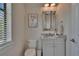 Well-lit half-bathroom featuring granite countertops, stylish mirror, and modern fixtures at 16406 Chapman Crossing Dr, Lithia, FL 33547