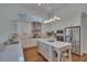Open kitchen featuring custom cabinets, stainless appliances, eat in island, and modern lighting at 16406 Chapman Crossing Dr, Lithia, FL 33547