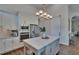 Open kitchen with white cabinets, a center island, stainless steel appliances and a sliding barn door at 16406 Chapman Crossing Dr, Lithia, FL 33547