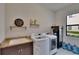 Functional laundry room with modern washer and dryer, sink, and ample storage space at 16406 Chapman Crossing Dr, Lithia, FL 33547