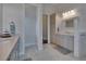Bright main bathroom with dual sink vanity and framed mirror, along with walk-in shower at 16406 Chapman Crossing Dr, Lithia, FL 33547