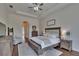 Bright main bedroom featuring hardwood floors, a ceiling fan, and an attached ensuite bathroom at 16406 Chapman Crossing Dr, Lithia, FL 33547