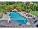 Aerial view of a private pool with a rock waterfall and surrounding lush landscaping at 16406 Chapman Crossing Dr, Lithia, FL 33547