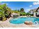Resort-style pool with a rock waterfall, surrounded by lush landscaping and lounge chairs at 16406 Chapman Crossing Dr, Lithia, FL 33547