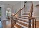 Elegant staircase featuring white risers, wood treads, and wrought iron spindles at 16406 Chapman Crossing Dr, Lithia, FL 33547