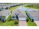 Waterfront home featuring a two-car garage, well-maintained landscaping, and a brick paved driveway at 19877 Sea Glass Cir, Land O Lakes, FL 34638