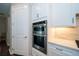 Gourmet kitchen with stainless steel double ovens, white cabinetry, and elegant countertop at 19877 Sea Glass Cir, Land O Lakes, FL 34638