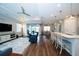 Living area, with seamless flow to dining and kitchen, featuring recessed lighting, a ceiling fan, and wood flooring at 19877 Sea Glass Cir, Land O Lakes, FL 34638