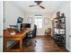 Comfortable home office with wood floors, decorative ceiling fan and large wooden desk area at 19877 Sea Glass Cir, Land O Lakes, FL 34638