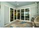 Covered outdoor patio featuring sliding glass doors, a BBQ grill, and views of the water at 19877 Sea Glass Cir, Land O Lakes, FL 34638