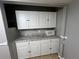 A cozy kitchen area features bright white cabinetry, granite countertops, and stainless microwave at 2068 San Marino N Way, Clearwater, FL 33763