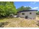Backyard with green grass and trees surrounding the back of the home at 2157 20Th Sw Ave, Largo, FL 33774