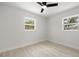 This bedroom offers two windows, ceiling fan, light walls, and wood-look flooring at 2157 20Th Sw Ave, Largo, FL 33774