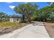 Inviting home featuring a neutral exterior, a new concrete driveway, and mature trees, perfect for outdoor enjoyment at 2157 20Th Sw Ave, Largo, FL 33774