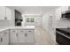 Modern kitchen featuring white cabinets, stainless steel appliances, and sleek countertops, seamlessly flowing into the living area at 2157 20Th Sw Ave, Largo, FL 33774