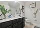 Well-lit bathroom featuring a black vanity, framed art, and decorative plants at 2234 Lennox Dale Ln, Brandon, FL 33510