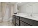 Bright bathroom with a dual sink vanity, shower with curtain, and large mirror at 2234 Lennox Dale Ln, Brandon, FL 33510