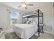 Bright bedroom featuring a bunk bed, ceiling fan, and large window with natural light and gray floors at 2234 Lennox Dale Ln, Brandon, FL 33510