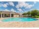 A kidney-shaped pool and cabana under a partly cloudy, blue sky at 2234 Lennox Dale Ln, Brandon, FL 33510