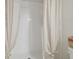 Close-up of a shower-tub combination with white tile and a neutral-toned curtain at 2234 Lennox Dale Ln, Brandon, FL 33510
