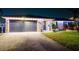 Beautiful home exterior at night featuring a well-manicured lawn and solar panels on the roof at 2401 66Th S Ave, St Petersburg, FL 33712