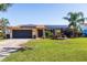 Charming single-story home featuring a well-manicured lawn, front garden and solar panels on the roof at 2401 66Th S Ave, St Petersburg, FL 33712