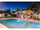 Backyard pool with pergola, chairs and table, string lights, landscaping and ambient lighting for a relaxing outdoor experience at 2401 66Th S Ave, St Petersburg, FL 33712