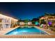 Backyard pool with outdoor kitchen and pergola under the night sky at 2401 66Th S Ave, St Petersburg, FL 33712