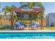 A backyard featuring a pool and pergola with chairs and table set, ideal for relaxation and entertainment by the water at 2401 66Th S Ave, St Petersburg, FL 33712