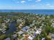 Aerial view showcasing the home's prime location within a waterfront community near lush landscaping and open water at 261 Kentucky Ave, Crystal Beach, FL 34681