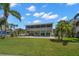 Expansive backyard with lush lawn, swimming pool, screened lanai and mature palms creating a private oasis at 261 Kentucky Ave, Crystal Beach, FL 34681