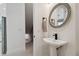 Modern powder room with pedestal sink, decorative mirror and clean, white walls at 2758 5Th S Ave, St Petersburg, FL 33712