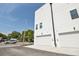 Modern white townhome featuring multiple garage doors, minimalist landscaping, and clear blue skies at 2758 5Th S Ave, St Petersburg, FL 33712