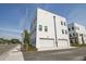 Modern white townhomes featuring multiple garage doors, minimalist landscaping, and clear blue skies at 2758 5Th S Ave, St Petersburg, FL 33712