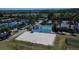 Aerial view of tennis and pickleball courts, a sand volleyball pit, and playground with nearby lake at 29903 Baywood Ln, Wesley Chapel, FL 33543