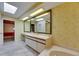 Spacious bathroom featuring vanity, bathtub, skylight and patterned wallpaper at 29903 Baywood Ln, Wesley Chapel, FL 33543