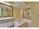 Bathroom featuring a bathtub, a double vanity, and floral wallpaper at 29903 Baywood Ln, Wesley Chapel, FL 33543