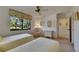 Sunlit bedroom with two twin beds, a ceiling fan, and a view of the landscaped yard at 29903 Baywood Ln, Wesley Chapel, FL 33543