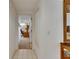 Tiled hallway leading to a bright room with a desk, chair, and natural light at 29903 Baywood Ln, Wesley Chapel, FL 33543