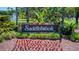 Stone welcome sign for Saddlebrook community featuring a well-maintained flowerbed and lush landscaping at 29903 Baywood Ln, Wesley Chapel, FL 33543
