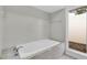 Clean bathroom featuring a soaking tub, tiled walls, and a window bringing in natural light at 30 Pinetree Ct, Palm Harbor, FL 34683