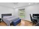 Cozy bedroom featuring a large window, hardwood floors, and a comfortable bed at 30 Pinetree Ct, Palm Harbor, FL 34683
