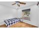 Simple bedroom with a large window and neutral colors, with hardwood floors and a twin bed at 30 Pinetree Ct, Palm Harbor, FL 34683