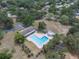 Aerial view of a community pool and clubhouse area, surrounded by greenery and ample parking at 30 Pinetree Ct, Palm Harbor, FL 34683