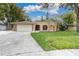 Charming single-story home boasting a large front yard and arched entryway at 30 Pinetree Ct, Palm Harbor, FL 34683